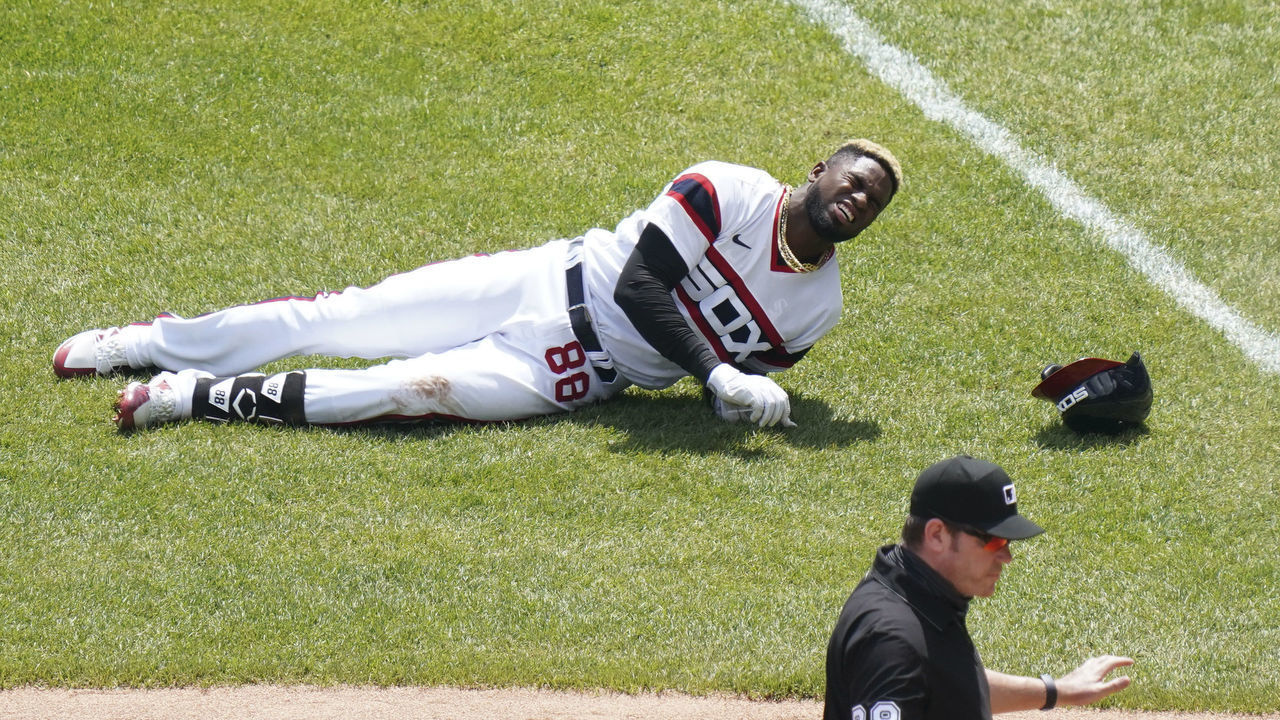 CHICAGO, ILLINOIS - MAY 02: Luis Robert #88 of the Chicago White Sox gets injured after reaching first base on a single during the first inning of a game against the Cleveland Indians at Guaranteed Rate Field on May 02, 2021 in Chicago, Illinois.