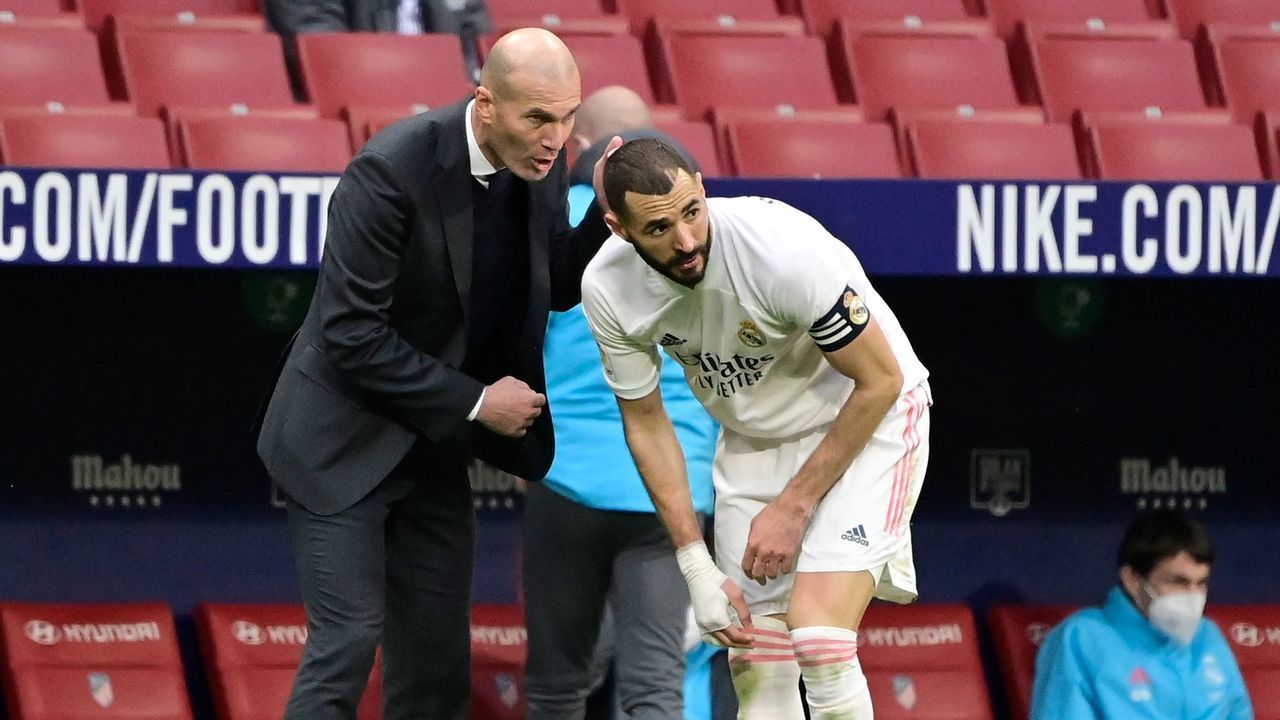 Real Madrid's French coach Zinedine Zidane (L) talks to Real Madrid's French forward Karim Benzema during the Spanish league football match Club Atletico de Madrid against Real Madrid CF at the Wanda Metropolitano stadium in Madrid on March 7, 2021.
