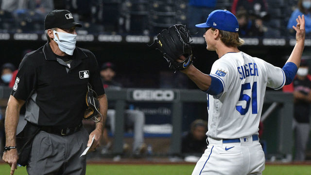 KANSAS CITY, MISSOURI - MAY 05: Starting pitcher Brady Singer #51 of the Kansas City Royals gestures to plate umpire Angel Hernandez as he leaves a game against the Cleveland Indians in the sixth inning at Kauffman Stadium on May 05, 2021 in Kansas City, Missouri.