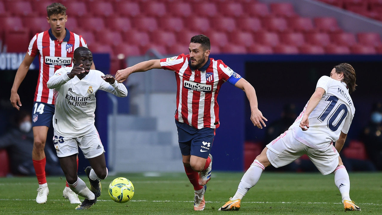 MADRID, SPAIN - MARCH 07: Koke of Atletico de Madrid is challenged by Ferland Mendy and Luka Modric of Real Madrid during the La Liga Santander match between Atletico de Madrid and Real Madrid at Estadio Wanda Metropolitano on March 07, 2021 in Madrid, Spain. Sporting stadiums around Spain remain under strict restrictions due to the Coronavirus Pandemic as Government social distancing laws prohibit fans inside venues resulting in games being played behind closed doors.