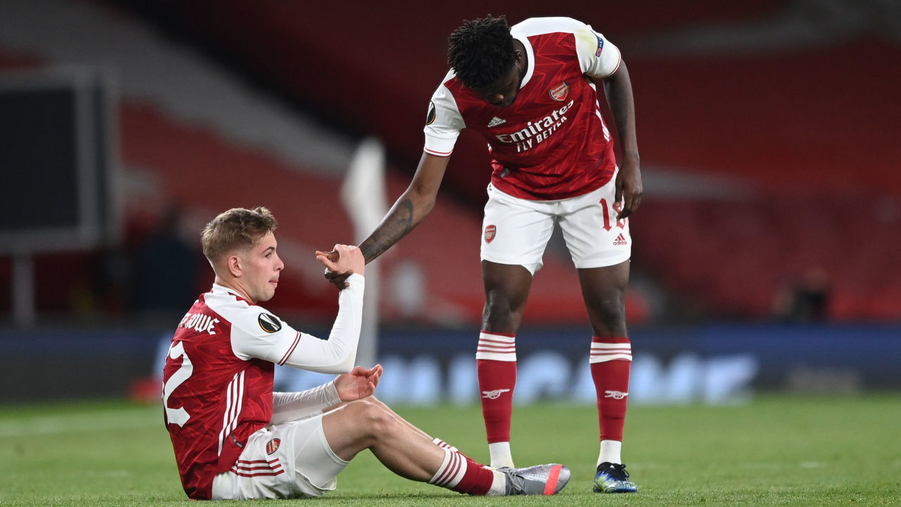 LONDON, ENGLAND - MAY 06: Emile Smith Rowe (L) of Arsenal is helped up by team mate Thomas Partey as they both look dejected following the UEFA Europa League Semi-final Second Leg match between Arsenal and Villareal CF at Emirates Stadium on May 06, 2021 in London, England. Sporting stadiums around Europe remain under strict restrictions due to the Coronavirus Pandemic as Government social distancing laws prohibit fans inside venues resulting in games being played behind closed doors.