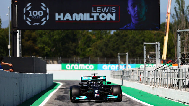 BARCELONA, SPAIN - MAY 08: Pole position qualifier Lewis Hamilton of Great Britain and Mercedes GP pulls into parc ferme under a banner celebrating his 100 pole positions during qualifying for the F1 Grand Prix of Spain at Circuit de Barcelona-Catalunya on May 08, 2021 in Barcelona, Spain.