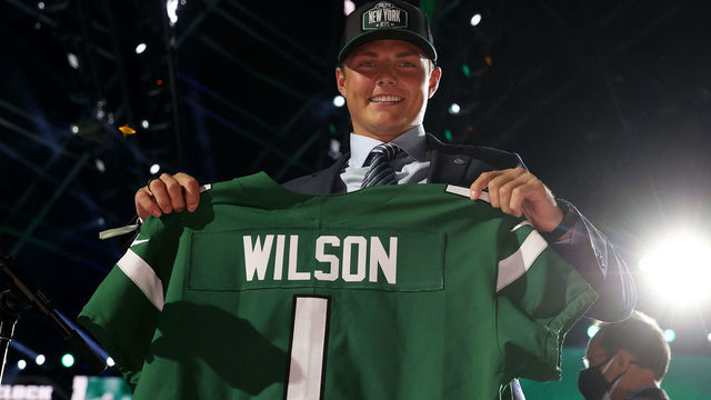 CLEVELAND, OHIO - APRIL 29: Zach Wilson holds a jersey onstage after being drafted second by the New York Jets during round one of the 2021 NFL Draft at the Great Lakes Science Center on April 29, 2021 in Cleveland, Ohio.