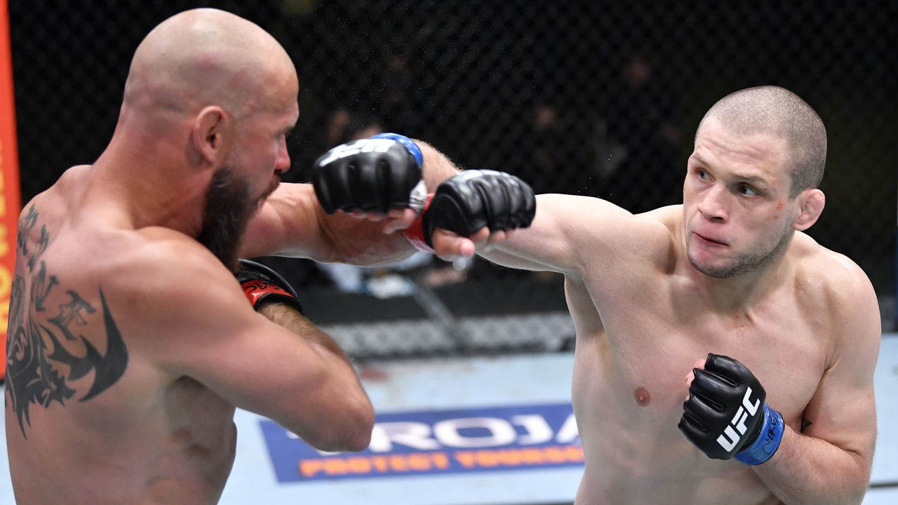 LAS VEGAS, NEVADA - MAY 08: (R-L) Alex Morono punches Donald 'Cowboy' Cerrone in a welterweight fight during the UFC Fight Night event at UFC APEX on May 08, 2021 in Las Vegas, Nevada.