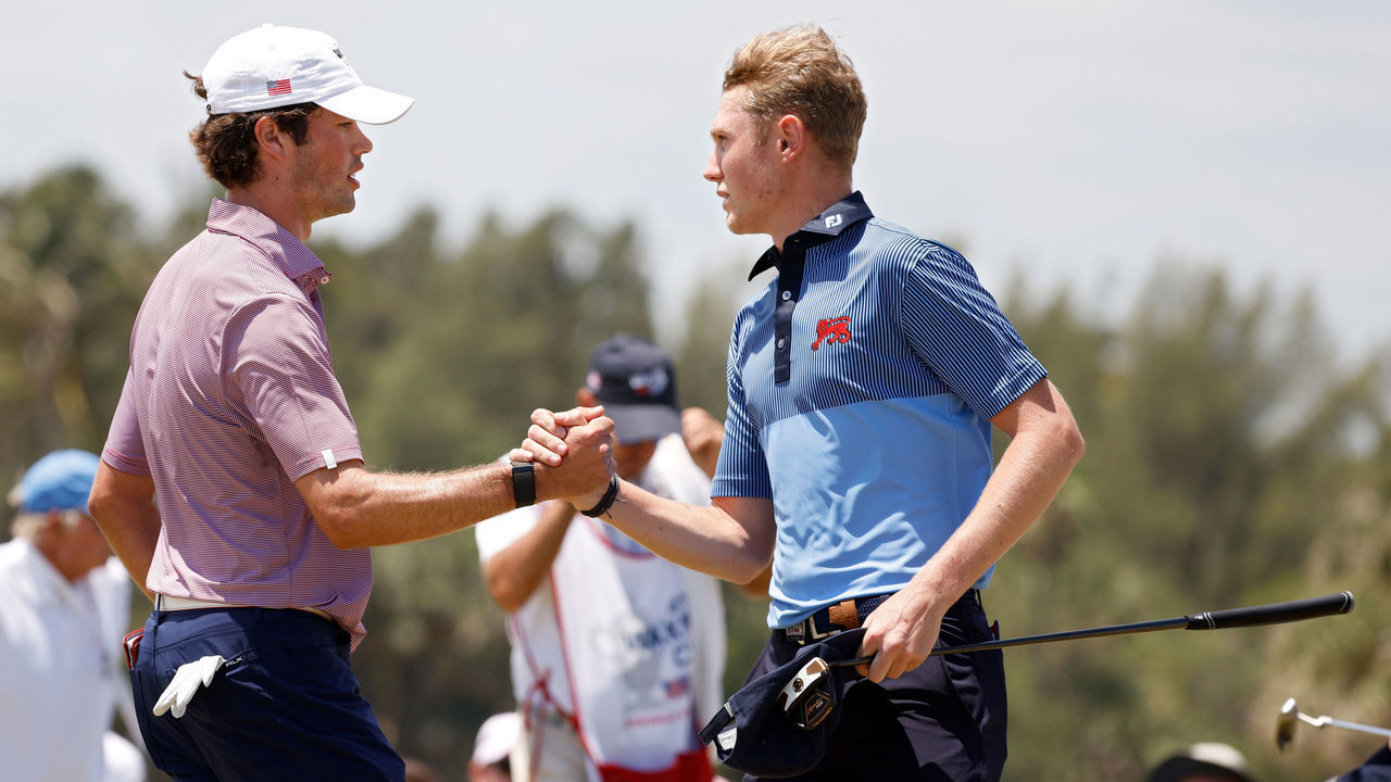 JUNO BEACH, FLORIDA - MAY 09: Cole Hammer of Team USA (L) and Ben Schmidt of Team Great Britain and Ireland shake hands on the 18th green after their match during Sunday foursomes matches on Day Two of The Walker Cup at Seminole Golf Club on May 09, 2021 in Juno Beach, Florida.