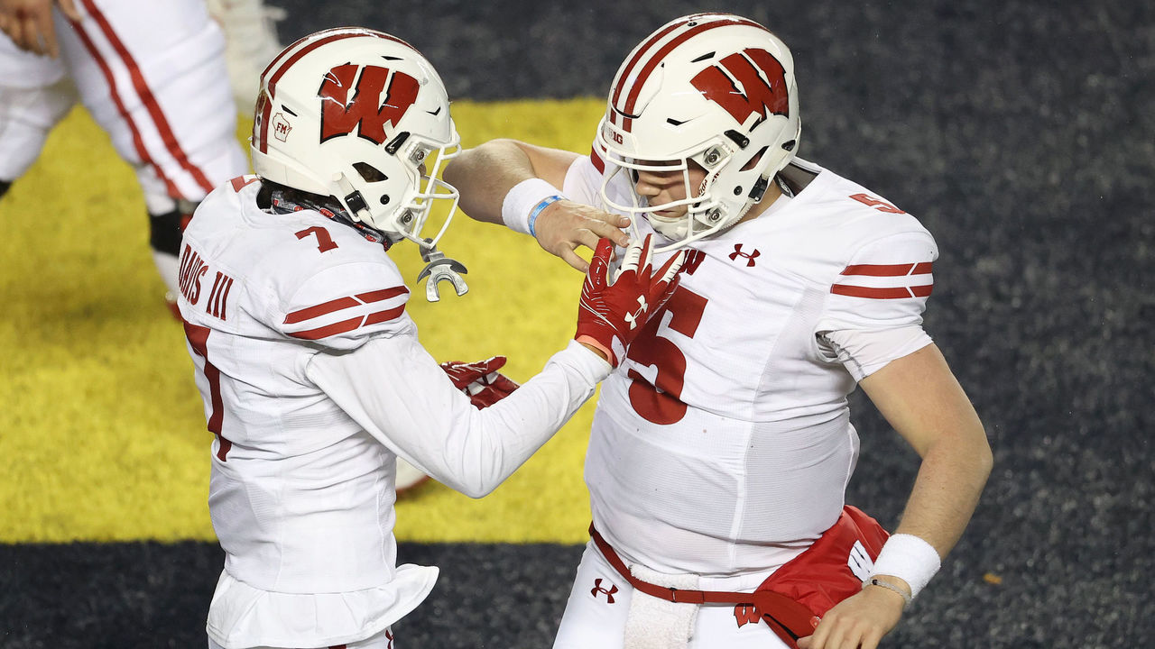 ANN ARBOR, MICHIGAN - NOVEMBER 14: Danny Davis III #7 of the Wisconsin Badgers celebrates his second half touchdown with Graham Mertz #5 while playing the Michigan Wolverines at Michigan Stadium on November 14, 2020 in Ann Arbor, Michigan.