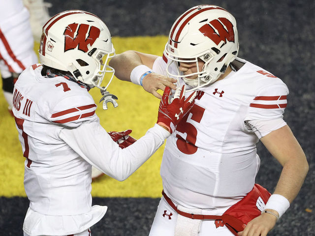 ANN ARBOR, MICHIGAN - NOVEMBER 14: Danny Davis III #7 of the Wisconsin Badgers celebrates his second half touchdown with Graham Mertz #5 while playing the Michigan Wolverines at Michigan Stadium on November 14, 2020 in Ann Arbor, Michigan.