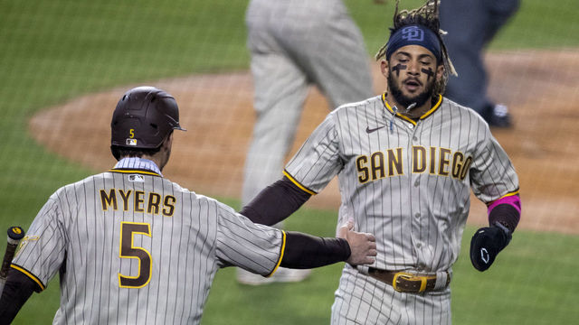 LOS ANGELES, CA - APRIL 22, 2021: San Diego Padres shortstop Fernando Tatis Jr. (23) gets a hand slap from San Diego Padres right fielder Wil Myers (5) after scoring on an RBI single by San Diego Padres third baseman Manny Machado (13) against the Dodgers in the fourth inning at Dodger Stadium on April 22, 2021 in Los Angeles, California.(Gina Ferazzi / Los Angeles Times via Getty Images)