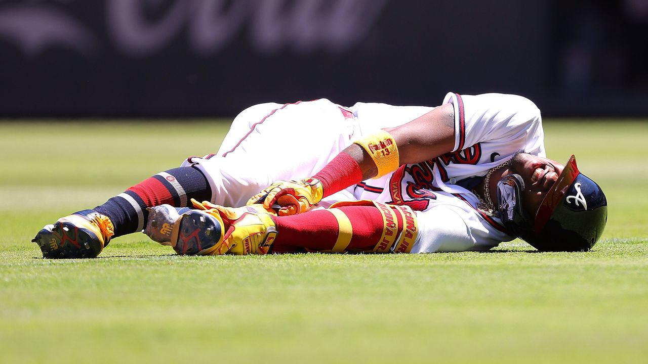 ATLANTA, GEORGIA - MAY 13: Ronald Acuna Jr. #13 of the Atlanta Braves grabs his left ankle after running out a ground ball down first base in the seventh inning at Truist Park on May 13, 2021 in Atlanta, Georgia. After a review, the call on the field was overturned and Acuna Jr. was called out to end the seventh inning.