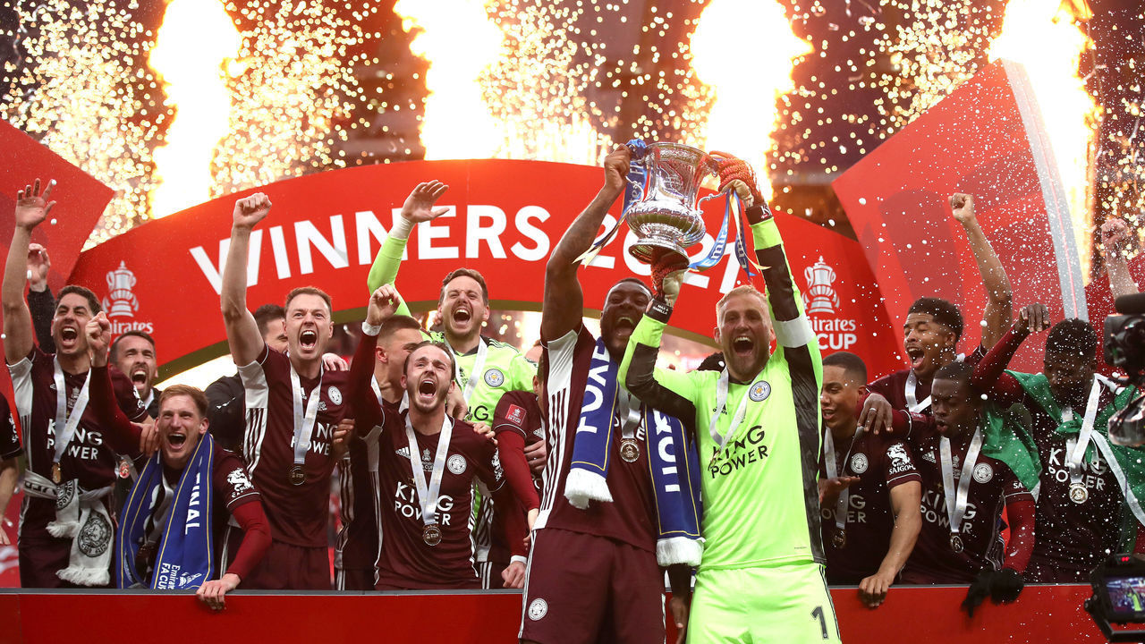 LONDON, ENGLAND - MAY 15: Kasper Schmeichel and Wes Morgan of Leicester City lift the Emirates FA Cup Trophy in celebration with team mates following The Emirates FA Cup Final match between Chelsea and Leicester City at Wembley Stadium on May 15, 2021 in London, England. A limited number of around 21,000 fans, subject to a negative lateral flow test, will be allowed inside Wembley Stadium to watch this year's FA Cup Final as part of a pilot event to trial the return of large crowds to UK venues.