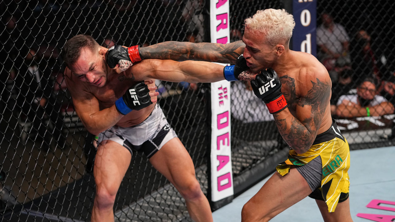 HOUSTON, TEXAS - MAY 15: (R-L) Charles Oliveira of Brazil punches Michael Chandler in their UFC lightweight championship bout at Toyota Center on May 15, 2021 in Houston, Texas.