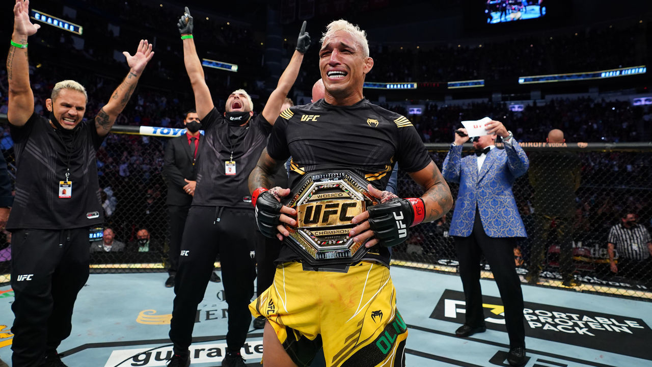 HOUSTON, TEXAS - MAY 15: Charles Oliveira of Brazil reacts as UFC President Dana White places the UFC lightweight championship belt around his waist after defeating Michael Chandler at Toyota Center on May 15, 2021 in Houston, Texas.