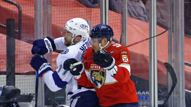 SUNRISE, FLORIDA - MAY 16: Sam Bennett #9 of the Florida Panthers checks Victor Hedman #77 of the Tampa Bay Lightning into the boards during the first period in Game One of the First Round of the 2021 Stanley Cup Playoffs at the BB&T Center on May 16, 2021 in Sunrise, Florida.