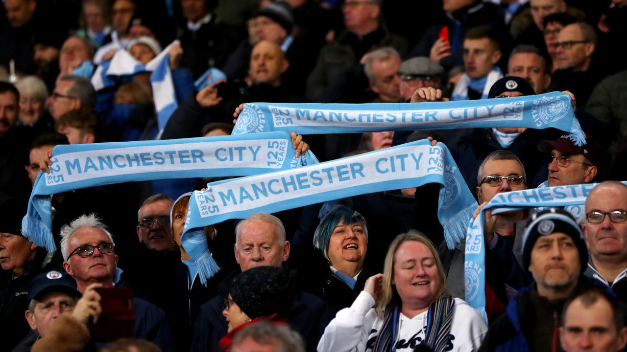 MANCHESTER, ENGLAND - DECEMBER 07: Manchester City fans hold up scarves during the Premier League match between Manchester City and Manchester United at Etihad Stadium on December 07, 2019 in Manchester, United Kingdom.