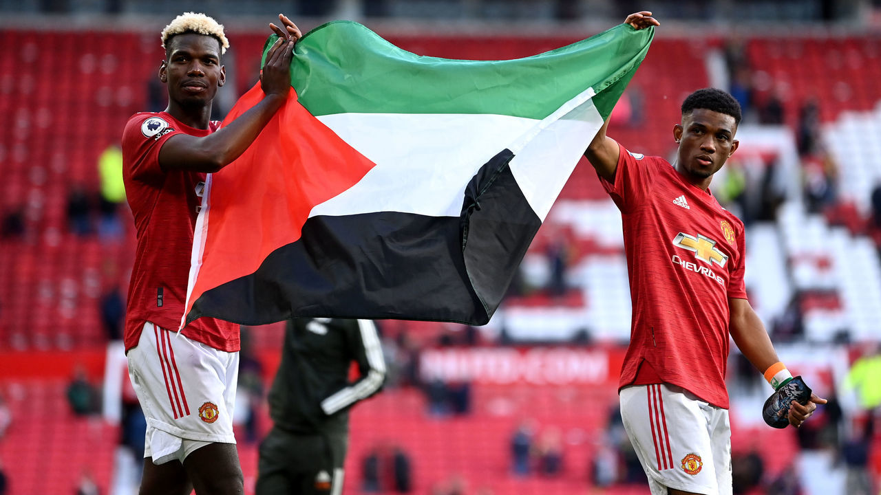 Manchester United's Paul Pogba (left) and Amad Diallo hold up the flag of Palestine after the Premier League match at Old Trafford, Manchester. Picture date: Tuesday May 18, 2021.