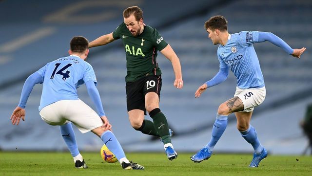 Tottenham Hotspur's English striker Harry Kane (C) vies with Manchester City's French defender Aymeric Laporte (L) and Manchester City's English defender John Stones during the English Premier League football match between Manchester City and Tottenham Hotspur at the Etihad Stadium in Manchester, north west England, on February 13, 2021.