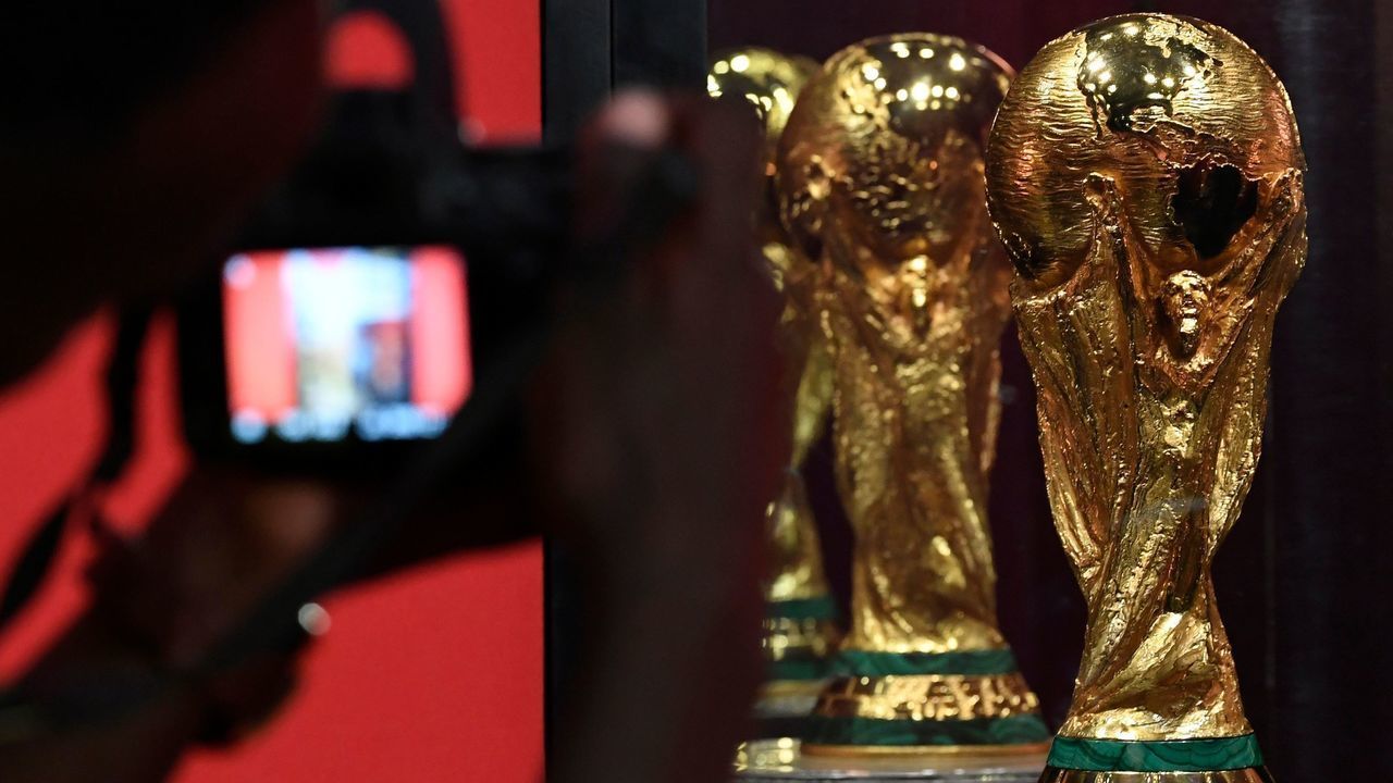 A man takes a photo of the FIFA World Cup Trophy displayed at the Kenyatta International Confernce Center (KICC) in Nairobi on February 27, 2018 part of the football organisation's world trophy tour. The trophy is making its way across Africa to 11 countries, part of a world tour that sees the trophy presented at 91 cities in 51 countries spread over six continents. / AFP PHOTO / SIMON MAINA