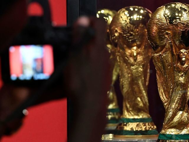A man takes a photo of the FIFA World Cup Trophy displayed at the Kenyatta International Confernce Center (KICC) in Nairobi on February 27, 2018 part of the football organisation's world trophy tour. The trophy is making its way across Africa to 11 countries, part of a world tour that sees the trophy presented at 91 cities in 51 countries spread over six continents. / AFP PHOTO / SIMON MAINA