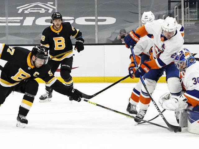 BOSTON, MA - APRIL 16: New York Islanders defenseman Nick Leddy (2) blocks Boston Bruins center Patrice Bergeron (37) from getting a shot on New York Islanders goalie Ilya Sorokin (30) during a game between the Boston Bruins and the New York Islanders on April 16, 2021 at TD garden in Boston, Massachusetts.