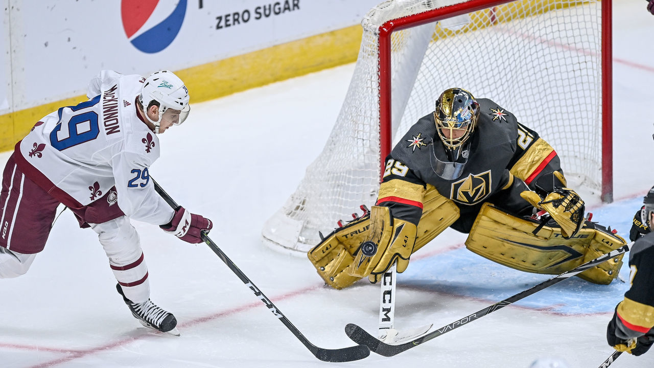 DENVER, CO - FEBRUARY 22: Colorado Avalanche center Nathan MacKinnon (29) tries to bat the pick past Vegas Golden Knights goaltender Marc-Andre Fleury (29) during a game between the Vegas Golden Knights and the Colorado Avalanche at Ball Arena in Denver, Colorado on February 22, 2021. The Colorado Avalanche wore retro-themed uniforms with logos of the Quebec Nordiques.