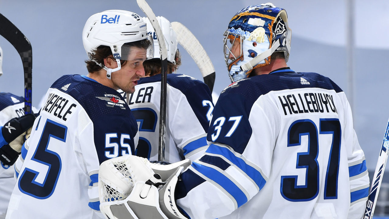 EDMONTON, AB - MAY 19: Mark Scheifele #55 and Connor Hellebuyck #37 of the Winnipeg Jets celebrate after winning Game One of the First Round of the 2021 Stanley Cup Playoffs against the Edmonton Oilers on May 19, 2021 at Rogers Place in Edmonton, Alberta, Canada.