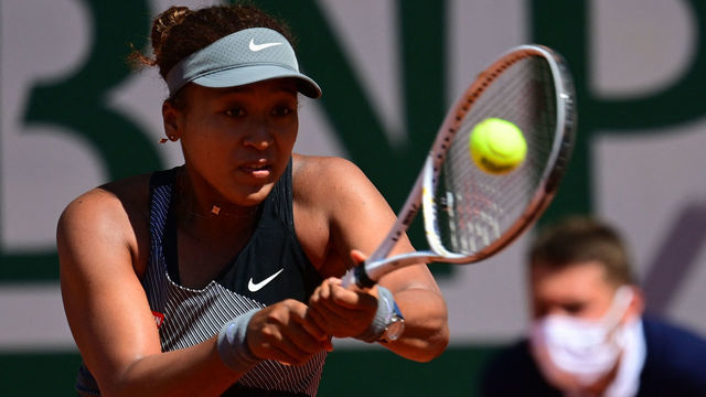 Japan's Naomi Osaka returns the ball to Romania's Patricia Maria Tig during their women's singles first round tennis match on Day 1 of The Roland Garros 2021 French Open tennis tournament in Paris on May 30, 2021.