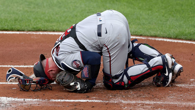 BALTIMORE, MARYLAND - JUNE 01: Catcher Mitch Garver #8 of the Minnesota Twins stays on the ground after being injured and leaving the game in the first inning against the Baltimore Orioles at Oriole Park at Camden Yards on June 01, 2021 in Baltimore, Maryland.