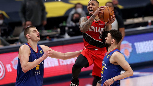 DENVER, COLORADO - JUNE 01: Damian Lillard #0 of the Portland Trail Blazers goes to the basket against Nikola Jokic #15 and Austin Rivers #25 of the Denver Nuggets in the first overtime during Game Five of their Western Conference first-round playoff series at Ball Arena on June 1, 2021 in Denver, Colorado.