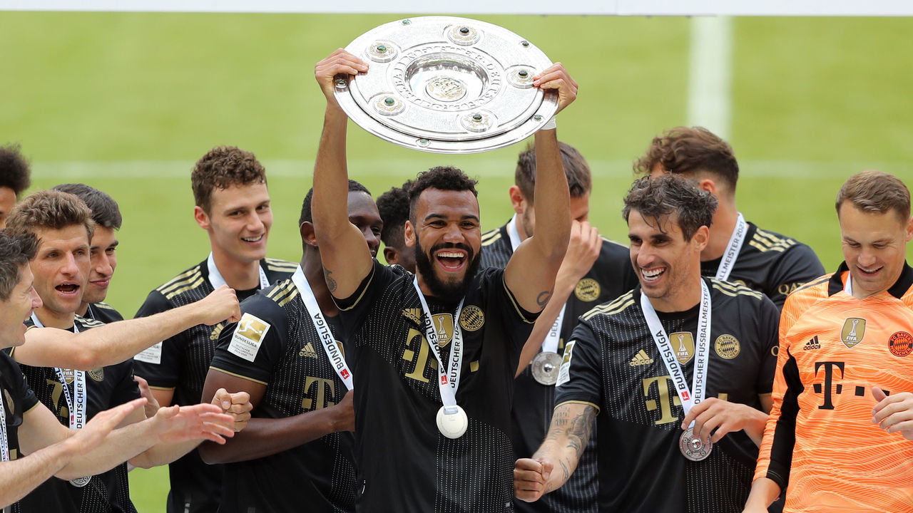 MUNICH, GERMANY - MAY 22: Eric Maxim Choupo Moting of Bayern Muenchen lifts the Bundesliga Meisterschale Trophy in celebration with players following the Bundesliga match between FC Bayern Muenchen and FC Augsburg at Allianz Arena on May 22, 2021 in Munich, Germany. After the Bavarian cabinet decided on first relaxations for outdoor events, the current Corona situation allows FC Bayern to have its last match of the season in front of 250 spectators in the Allianz Arena. Of these, 100 tickets are given to people from the health sector selected by the Ministry of Health.