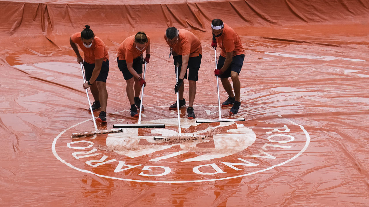 04 June 2021, France, Paris: Tennis: Grand Slam - French Open. A rain tarp is cleared of water by four groundskeepers. Photo: Frank Molter/dpa