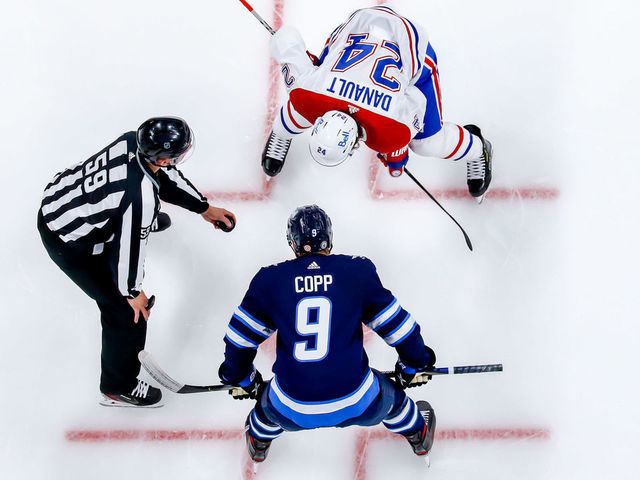 WINNIPEG, MB - JUNE 4: Phillip Danault #24 of the Montreal Canadiens gets set to take a second period face-off against Andrew Copp #9 of the Winnipeg Jets in Game Two of the Second Round of the 2021 Stanley Cup Playoffs at the Bell MTS Place on June 4, 2021 in Winnipeg, Manitoba, Canada.