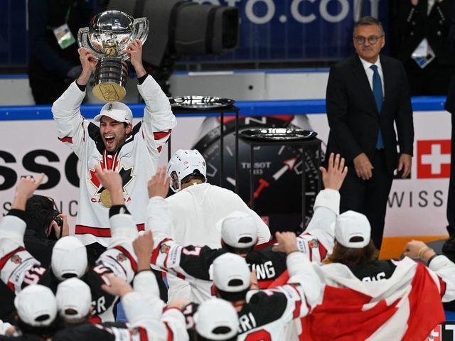 Canada's forward Adam Henrique (top L) holds up the trophy as Canada's players celebrate with the trophy after winning the IIHF Men's Ice Hockey World Championships final match between the Finland and Canada at the Arena Riga in Riga, Latvia, on June 5, 2021. - A 3-2 victory over Finland crowned Canada Ice Hockey World Champions 2021.