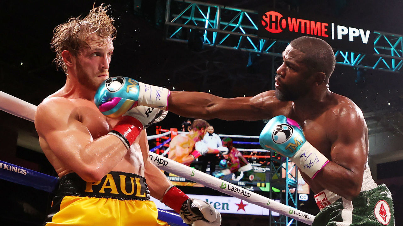 MIAMI GARDENS, FLORIDA - JUNE 06: Floyd Mayweather (R) punches Logan Paul during their contracted exhibition boxing match at Hard Rock Stadium on June 06, 2021 in Miami Gardens, Florida.