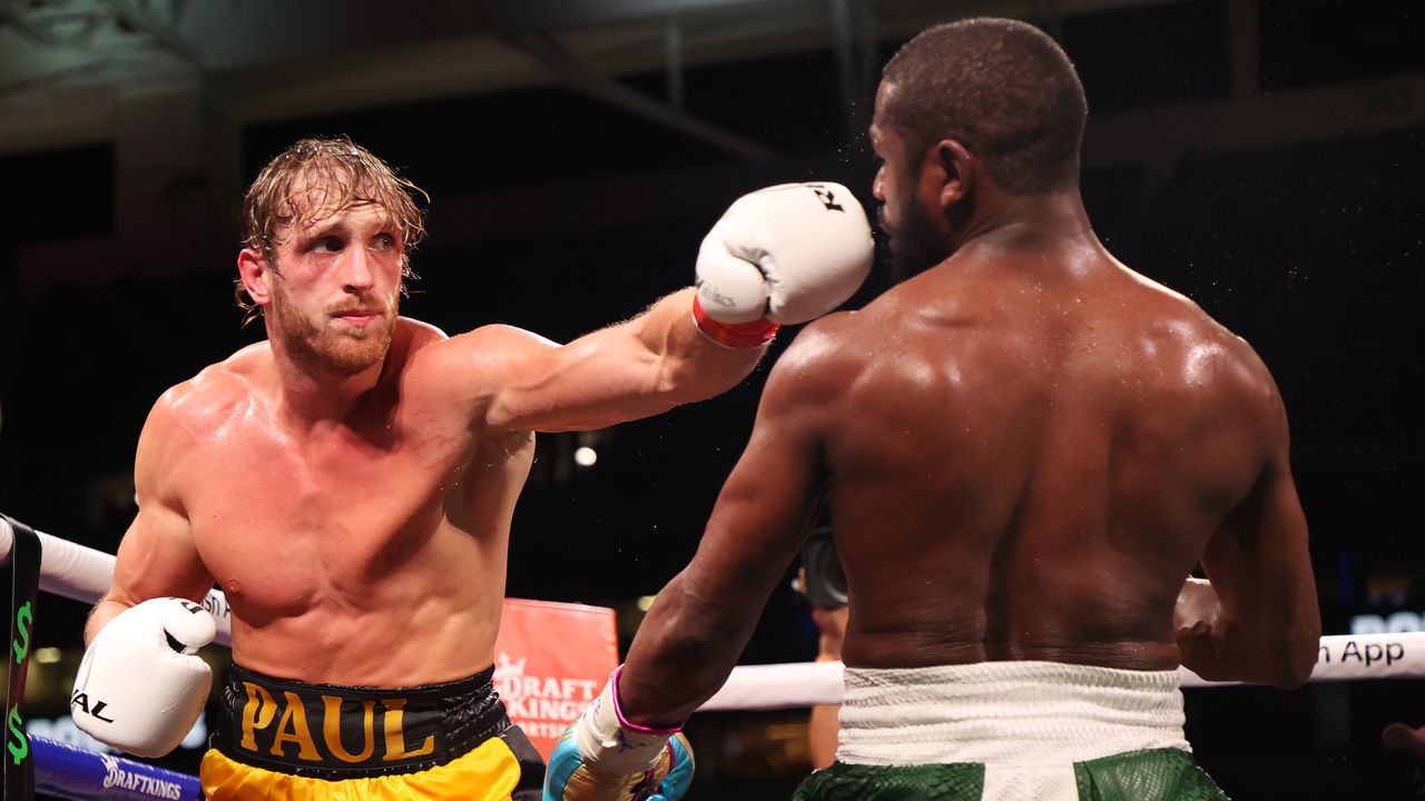 MIAMI GARDENS, FLORIDA - JUNE 06: Logan Paul (L) punches Floyd Mayweather during their contracted exhibition boxing match at Hard Rock Stadium on June 06, 2021 in Miami Gardens, Florida.