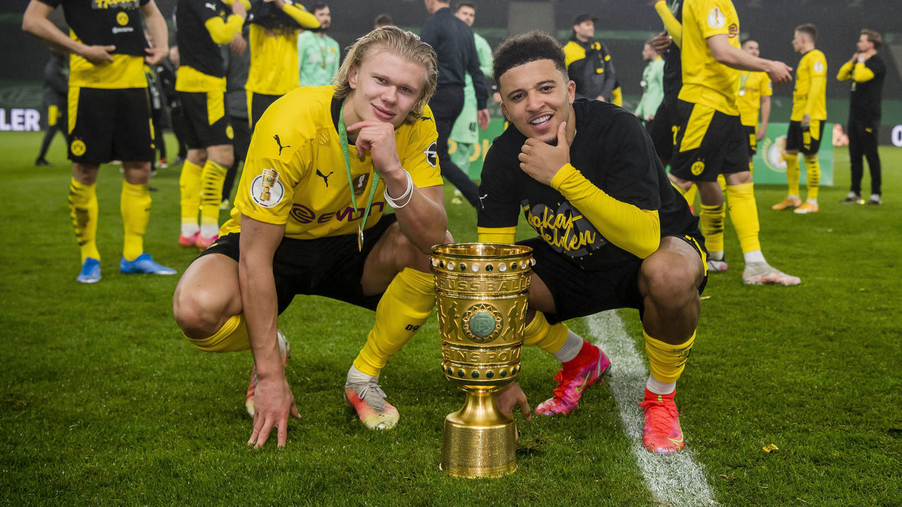 BERLIN, GERMANY - MAY 13: (L-R) Erling Haaland and Jadon Sancho of Borussia Dortmund pose with the trophy after the DFB Cup final match between RB Leipzig and Borussia Dortmund at Olympic Stadium on May 13, 2021 in Berlin, Germany. Sporting stadiums around Germany remain under strict restrictions due to the Coronavirus Pandemic as Government social distancing laws prohibit fans inside venues resulting in games being played behind closed doors.