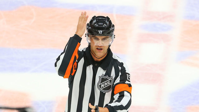 UNIONDALE, NY - JUNE 05: National Hockey League referee Jean Herbert (15) calls a slashing penalty during the Stanley Cup Playoffs Second Round game 4 between the Boston Bruins and the New York Islanders on June 5, 2021 at Nassau Veterans Memorial Coliseum in Uniondale, NY.