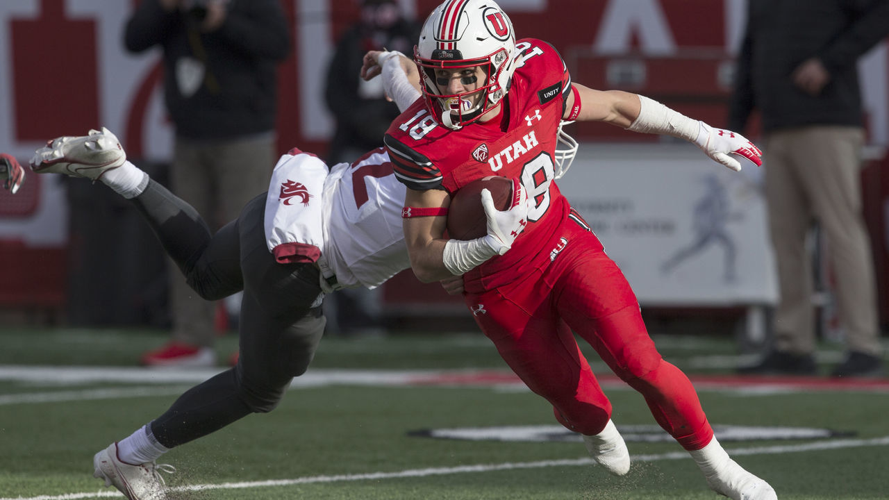 SALT LAKE CITY, UT - DECEMBER 19: Britain Covey #18 of the Utah Utes breaks a tackle attempt by Joey Hobert #12 of the Washington State Cougars during their game on December 19, 2020 at Rice Eccles Stadium in Salt Lake City, Utah.