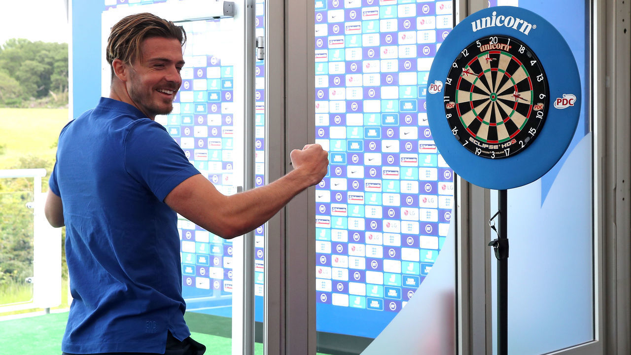 England's Jack Grealish plays a game of darts during the press conference at St George's Park, Burton. Picture date: Wednesday June 9, 2021.