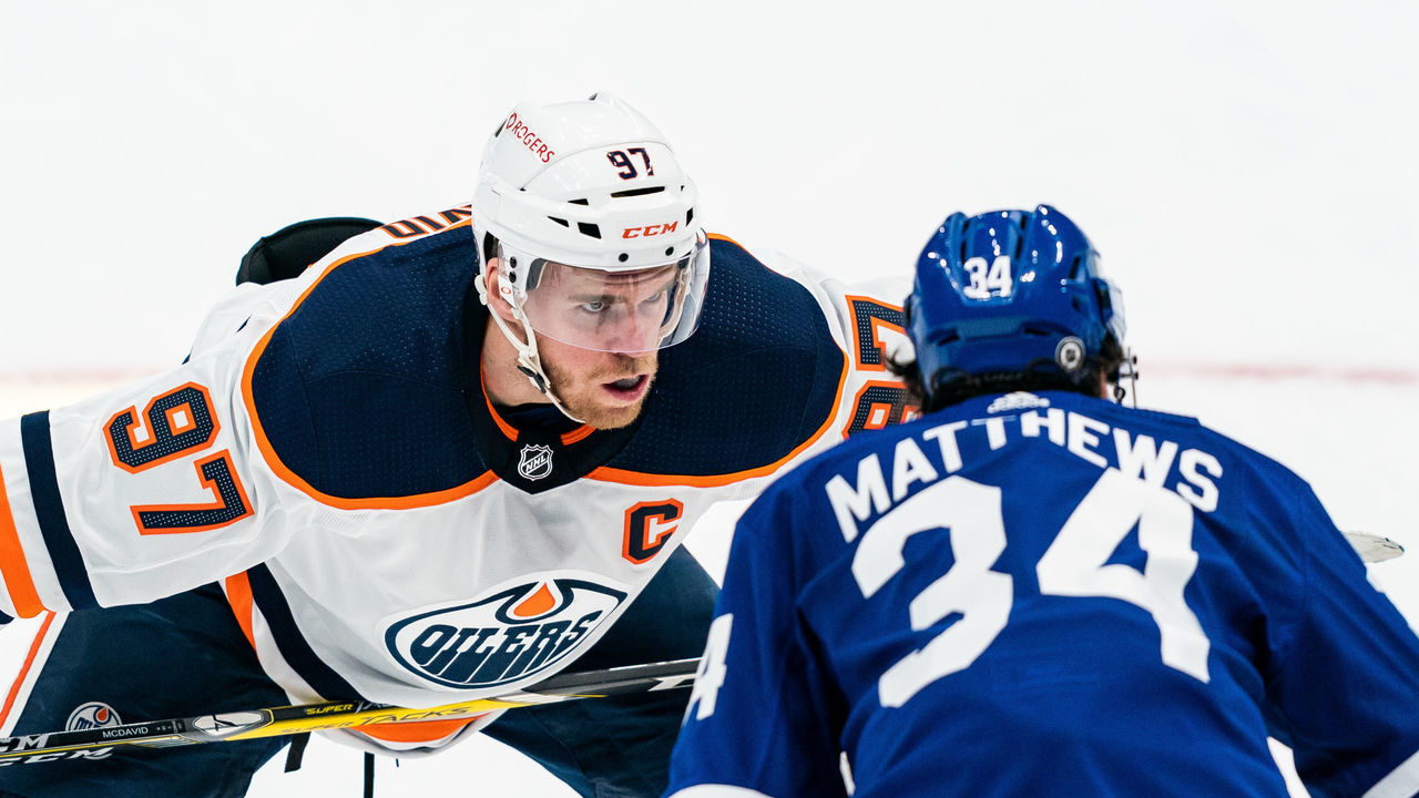TORONTO, ON - MARCH 29: Connor McDavid #97 of the Edmonton Oilers takes a face off against Auston Matthews #34 of the Toronto Maple Leafs during the first period at the Scotiabank Arena on March 29, 2021 in Toronto, Ontario, Canada.