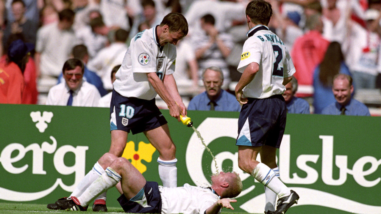 England's Paul Gascoigne (on floor) re-enacts the infamous Dentist's Chair incident with Teddy Sheringham (left) after scoring the second goal. Teammate Gary Neville (right) looks on