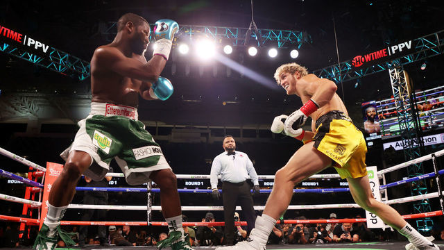 MIAMI GARDENS, FLORIDA - JUNE 06: Floyd Mayweather exchanges blows with Logan Paul (yellow shorts) during their contracted exhibition boxing match at Hard Rock Stadium on June 06, 2021 in Miami Gardens, Florida.