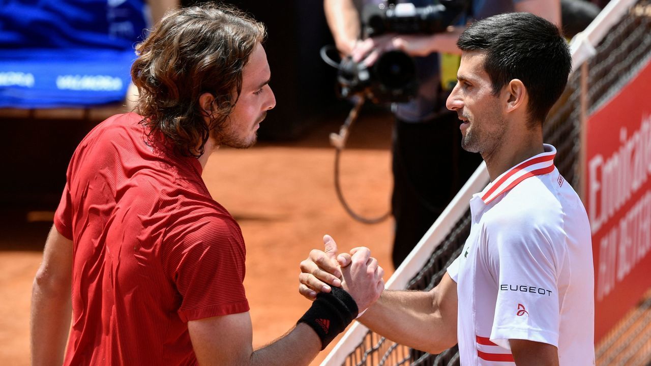Serbia's Novak Djokovic (R) taps hands with Greece's Stefanos Tsitsipas after winning their quarter final match of the Men's Italian Open at Foro Italico on May 15, 2021 in Rome, Italy.