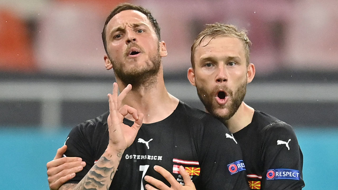 Austria's forward Marko Arnautovic (L) celebrates scoring his team's third goal with his teammate Austria's midfielder Konrad Laimer (R) during the UEFA EURO 2020 Group C football match between Austria and North Macedonia at the National Arena in Bucharest on June 13, 2021.