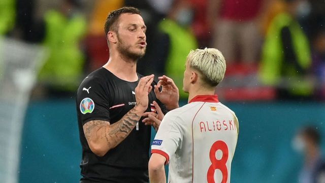 Austria's forward Marko Arnautovic (L) speaks with North Macedonia's defender Ezgjan Alioski at the end of the UEFA EURO 2020 Group C football match between Austria and North Macedonia at the National Arena in Bucharest on June 13, 2021.
