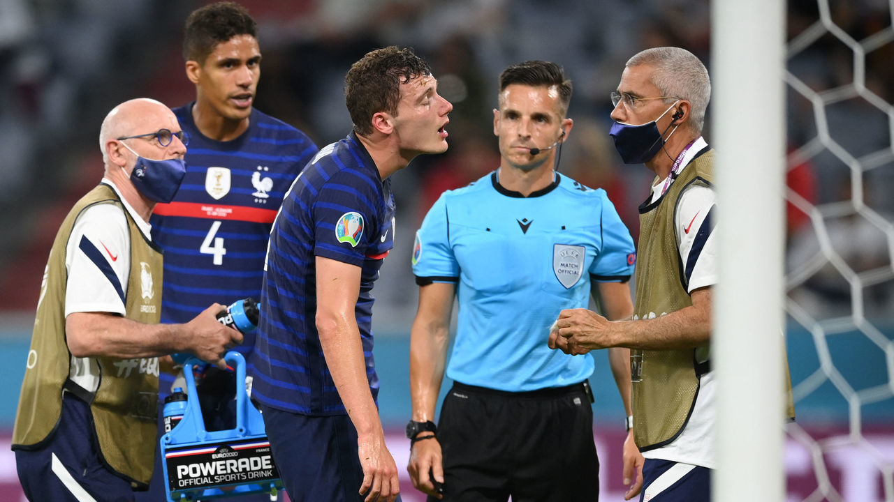 France's defender Benjamin Pavard (C) receives treatment after a collision during the UEFA EURO 2020 Group F football match between France and Germany at the Allianz Arena in Munich on June 15, 2021.