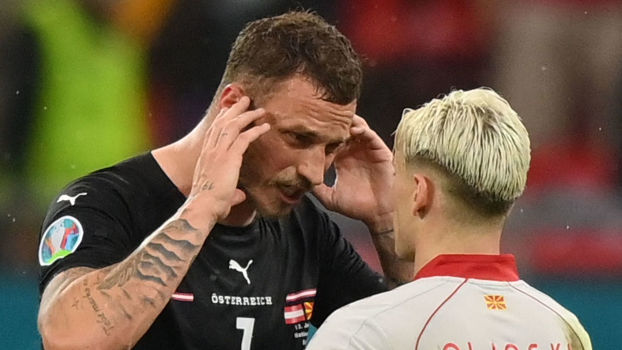 Austria's forward Marko Arnautovic (L) speaks with North Macedonia's defender Ezgjan Alioski at the end of the UEFA EURO 2020 Group C football match between Austria and North Macedonia at the National Arena in Bucharest on June 13, 2021.