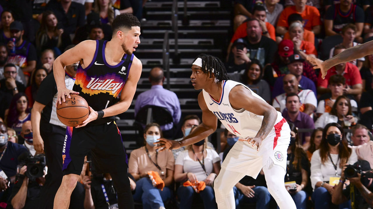 PHOENIX, AZ - JUNE 20: Devin Booker #1 of the Phoenix Suns handles the ball as Terance Mann #14 of the LA Clippers plays defense during the game during Game 1 of the Western Conference Finals of the 2021 NBA Playoffs on June 20, 2021 at Phoenix Suns Arena in Phoenix, Arizona. Mandatory Copyright Notice: Copyright 2021 NBAE