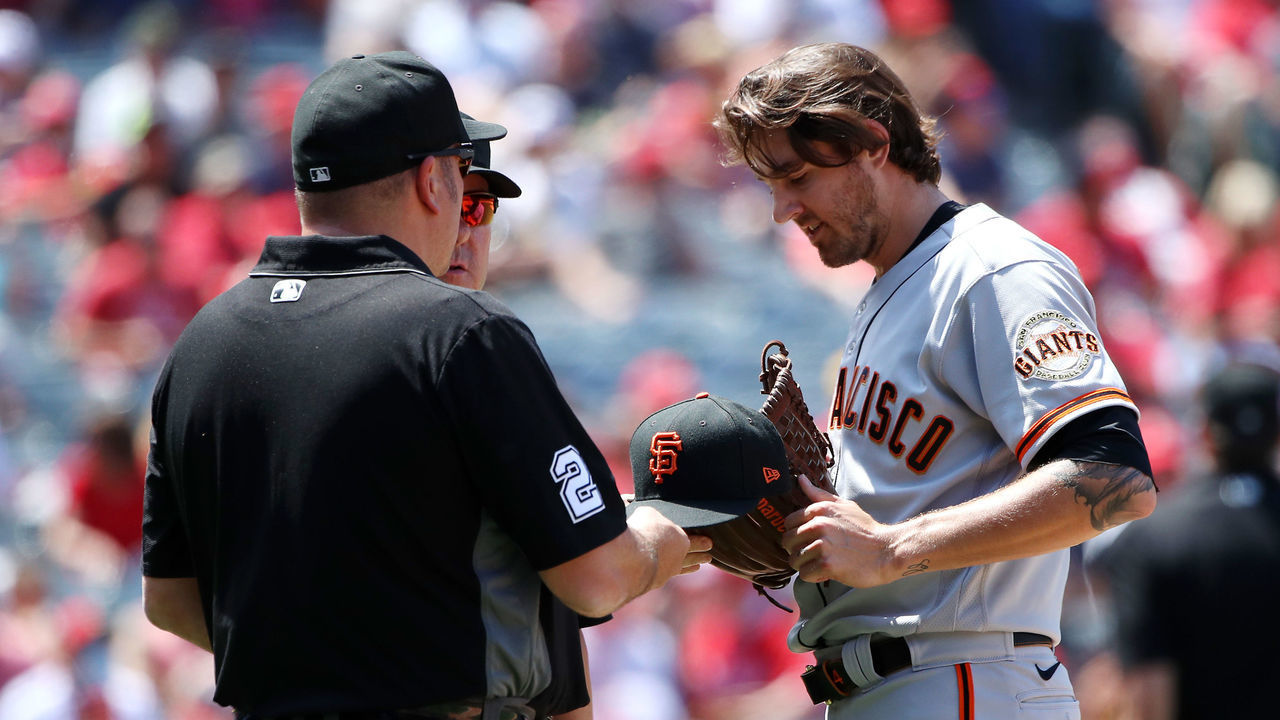 ANAHEIM, CALIFORNIA - JUNE 23: Pitcher Kevin Gausman #34 of the San Francisco Giants is checked for foreign substances by the umpires in the fourth inning against the Los Angeles Angels at Angel Stadium of Anaheim on June 23, 2021 in Anaheim, California.