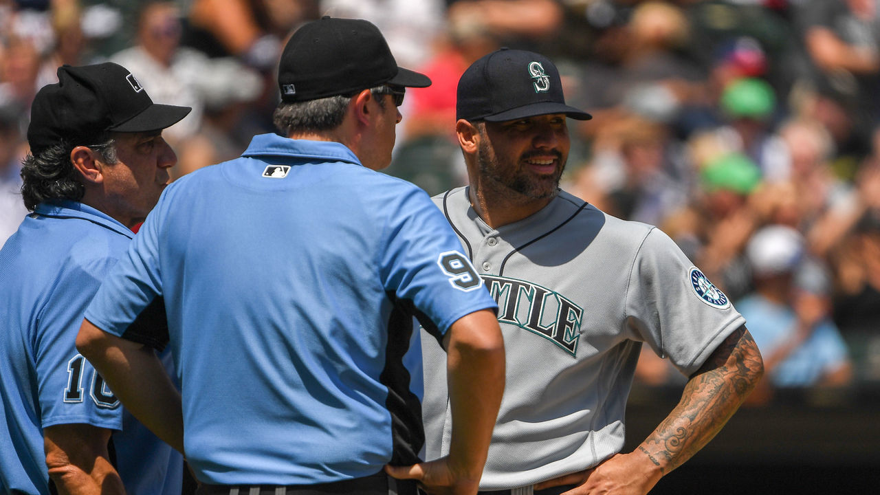 CHICAGO, ILLINOIS - JUNE 27: Umpires Phil Cuzzi #10 and Brian Gorman #9 talk to Hector Santiago #57 of the Seattle Mariners before ejecting him from the game after finding a substance on his glove in the fifth inning against the Chicago White Sox at Guaranteed Rate Field on June 27, 2021 in Chicago, Illinois. Today's game is a continuation from yesterday, which was suspended due to inclement weather.