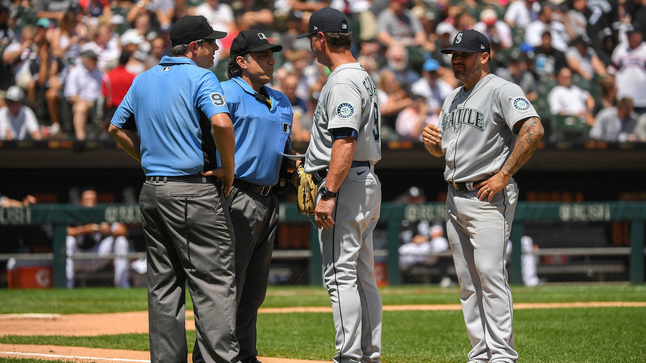 CHICAGO, ILLINOIS - JUNE 27: Umpires Phil Cuzzi #10 and Brian Gorman #9 talk to manager Scott Servais #9 before ejecting Hector Santiago #57 of the Seattle Mariners from the game after finding a substance on his glove in the fifth inning against the Chicago White Sox at Guaranteed Rate Field on June 27, 2021 in Chicago, Illinois. Today's game is a continuation from yesterday, which was suspended due to inclement weather.